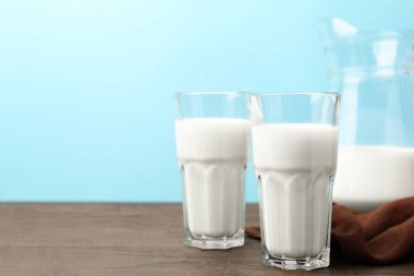 Açık mavi arka planda tahta masada taze süt. Metin için boşluk