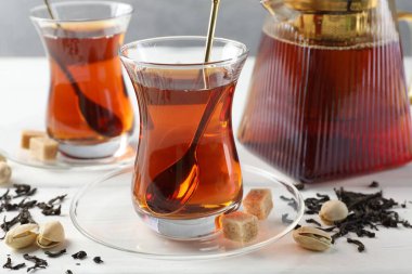 Lezzetli Türk çayı, şeker ve şam fıstığı beyaz ahşap masada, yakın plan.