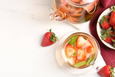 Aromatik çilekli meyve çayı ve beyaz mermer masada nane şekeri. Metin için boşluk