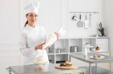 Pastacı mutfakta kremayla pasta süslüyor.