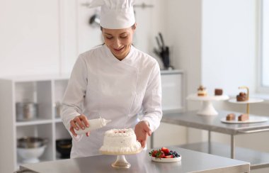 Bir şişe soslu şekerlemeci mutfakta pasta yapıyor.