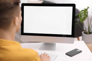 Ofisteki beyaz masada bilgisayarda çalışan bir adam, yakın plan. Tasarım için model