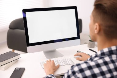 Ofisteki beyaz masada bilgisayarda çalışan bir adam, yakın plan. Tasarım için model