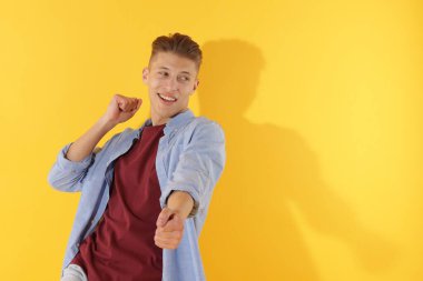 Sarı arka planda dans eden mutlu adam. Metin için boşluk