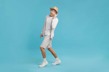 Açık mavi arka planda dans eden mutlu adam