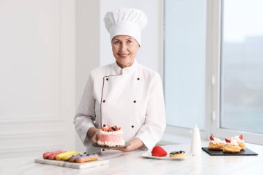 Mutfaktaki masada tatlıları olan profesyonel pasta şefi.