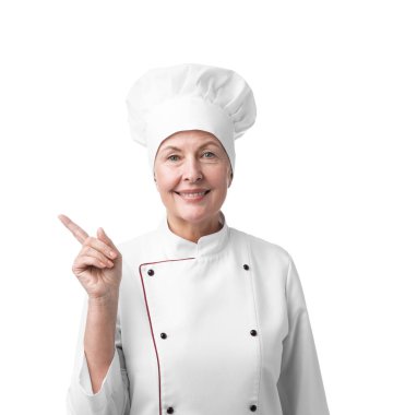 Profesyonel pasta şefi beyaz arka planda bir şeye işaret ediyor.