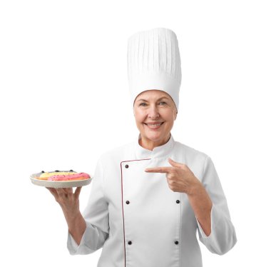 Profesyonel pasta şefi beyaz arka plandaki eklerlere işaret ediyor.