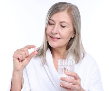 Kollajen hapı ve beyaz arka planda bir bardak suyla gülümseyen kadın.