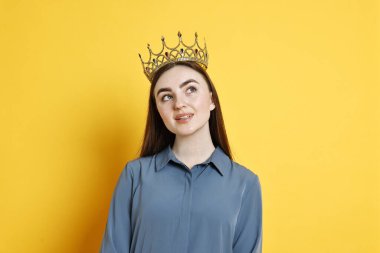 Sarı arka planda zarif taç giymiş bir kadın.
