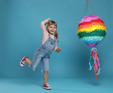 Parlak pinyatalı ve açık mavi arka planda mutlu bir kız.