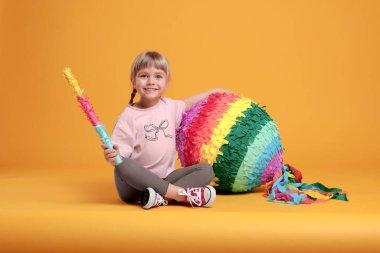 Parlak pinyatalı ve turuncu arka planda mutlu bir kız.