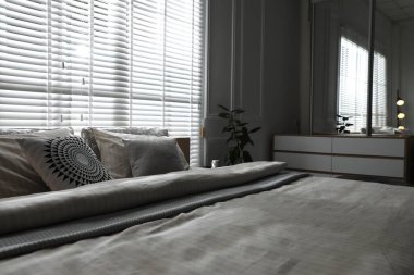 Şık bir odada yumuşak çarşafları olan rahat bir yatak, yakın çekim. İç tasarım