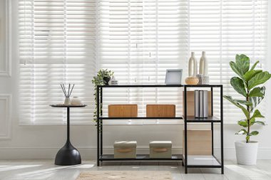 Pencerenin yanında farklı dekorları olan konsol masası. İç tasarım