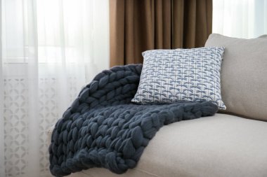 Odadaki kanepede örülmüş merino yün ekose.