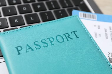 Pasaport, uçuş bileti ve laptop masada, yakın plan.