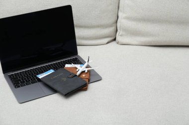 Pasaportlar, uçuş biletleri, uçak modeli ve koltukta dizüstü bilgisayar, mesaj için yer