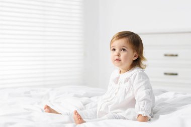 Evdeki yatakta tatlı küçük bir kız bebek. Metin için boşluk