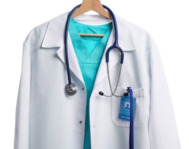 Beyaz arka planda asılı steteskop ve rozetli doktorun ceketi.