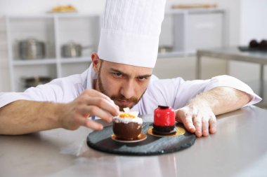 Şekerci mutfakta lezzetli bir tatlı hazırlıyor.