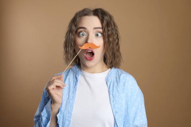 Bej arka planda sahte kağıt bıyıklı komik kadın.