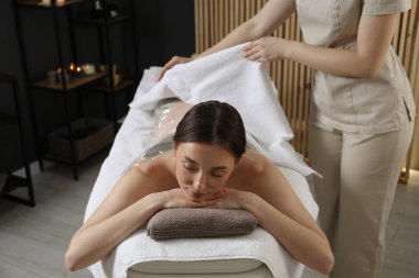 Spa vücut sargıları. Estetisyen kadın çarşaflı, kapalı