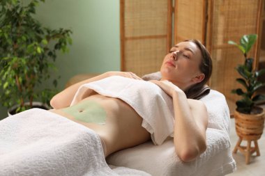 Vücut bakımı gören kadın spa salonunda tedavi görüyor