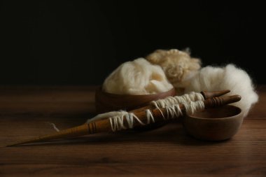 Spindles ve yumuşak beyaz yün ahşap tablo karşı siyah arkaplan, metin için boşluk
