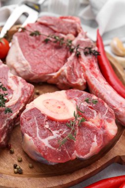 Açık gri masada çiğ et ve baharat parçaları, yakın plan.
