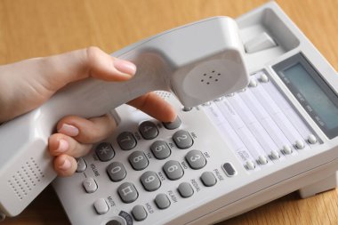 Ahşap masada telefonla arayan kadın, yakın plan.