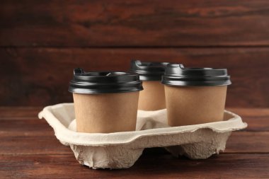 Kağıt kahve bardakları ahşap masanın üzerinde, yakın plan.