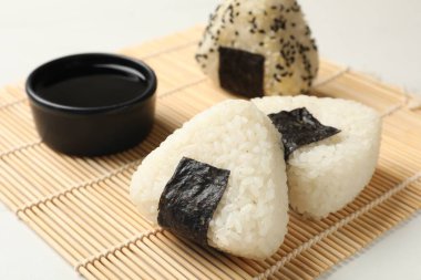 Pirinç topları (onigiri) ve soya sosu ışık masasında, yakın plan. Geleneksel Japon yemeği