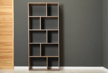 Boş raf ünitesi ve gri duvarın yanında katlanan ekran, metin için boşluk