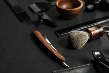 Siyah masada birçok farklı berber aleti var, yakın plan.
