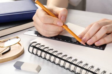 Işık masasında cetvel ve kalemle çizim yapan kadın, yakın plan.