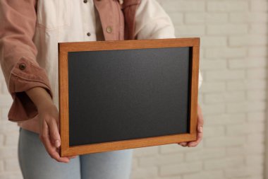 Elinde boş, küçük bir tahta tutan kadın, yakın plan.