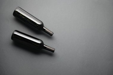 Gri arka planda şarap şişeleri, düz yatış. Metin için boşluk