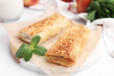 Lezzetli elmalı turtalar ve nane şekeri ışık masasında, yakın plan.