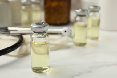 Cam şişelerde Hepatit aşısı ve beyaz mermer masada steteskop, yakın plan. Metin için boşluk