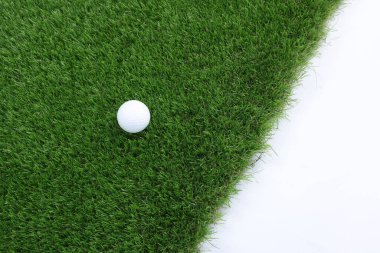 Beyaz arka planda golf topu ve yeşil çimenler, üst manzara. Metin için boşluk