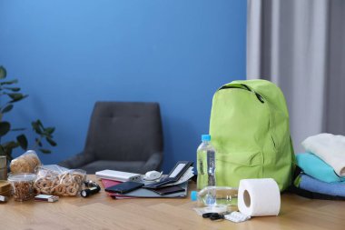 Hayatta kalma kiti. İçerideki ahşap masada farklı acil durum malzemeleri var.