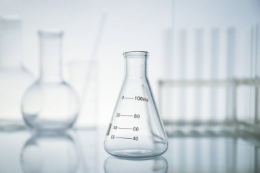 Ayna yüzeyindeki boş matarayı ışık arka planına karşı koy. Laboratuvar ekipmanları