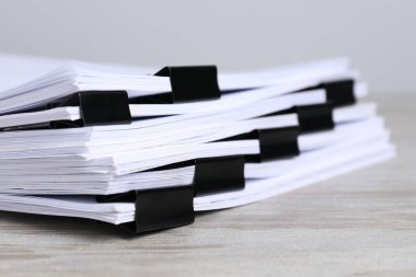 Tahta masadaki kağıtların olduğu ataçlar, yakın plan.