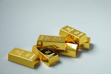 Açık gri arkaplanda parlak altın çubuklar, yakın plan