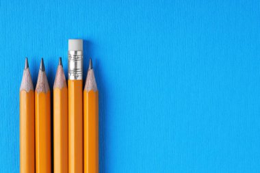 Açık mavi arka planda bir sürü kalem, üst manzara. Metin için boşluk