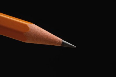 Siyah arkaplanda keskin bir grafit kalem, yakın plan.