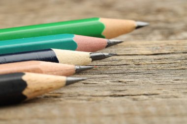 Tahta masadaki farklı grafit kalemler, yakın plan.