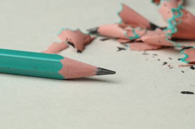 Işık arkaplanındaki grafit kalem ve talaşlar, yakın plan