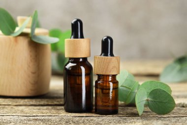 Kaliteli yağ ve okaliptüs yaprakları ahşap masada, yakın plan.