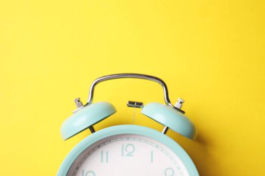 Sarı arka planda turkuaz alarm saati, üst görünüm